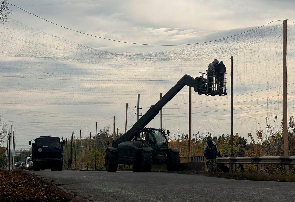 Ukrainian servicemen install anti-drone nets over a road, amid Russia’s attack on Ukraine, near the frontline town of Dobropillia in Donetsk region, Ukraine October 8, 2025. REUTERS/Stringer