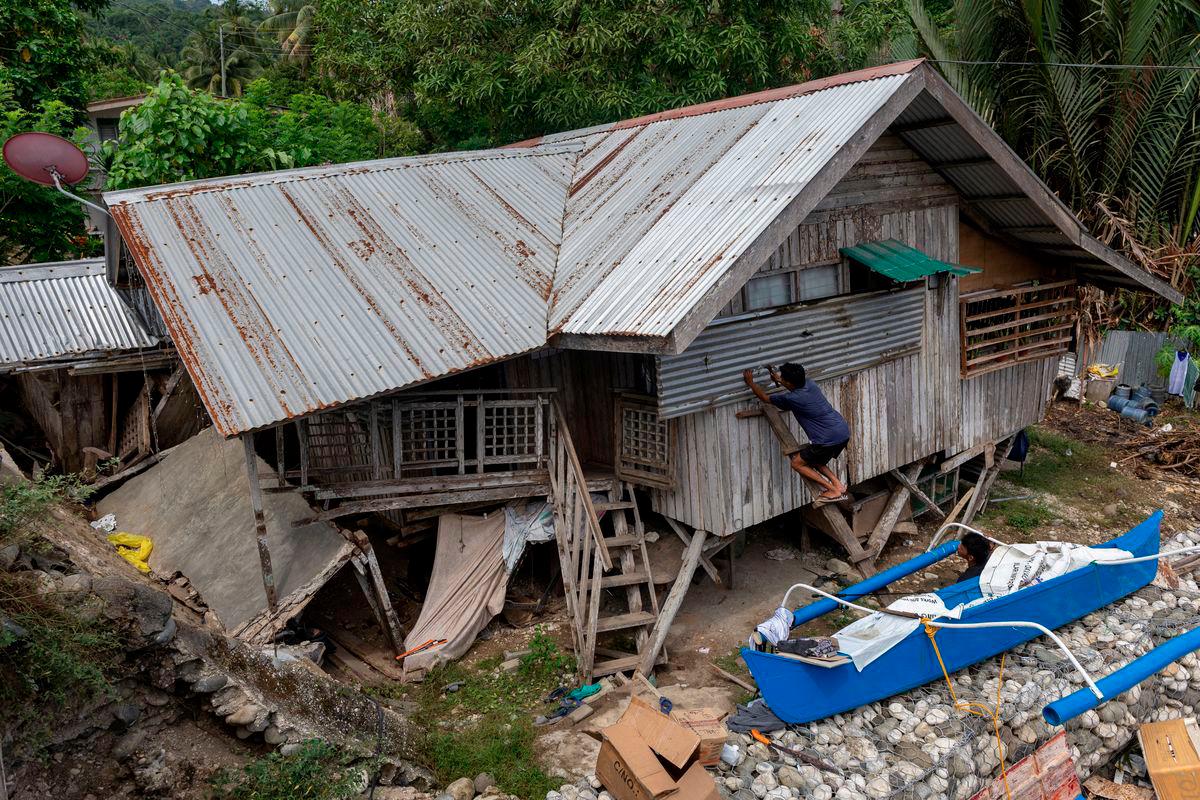 Saudara-mara Manuel Mandabon, pemilik rumah yang rosak berusia 87 tahun, menutup tingkap kediamannya selepas gempa bumi bermagnitud 7.4 melanda Manay, Davao Oriental, Filipina, pada 11 Oktober 2025. - REUTERS