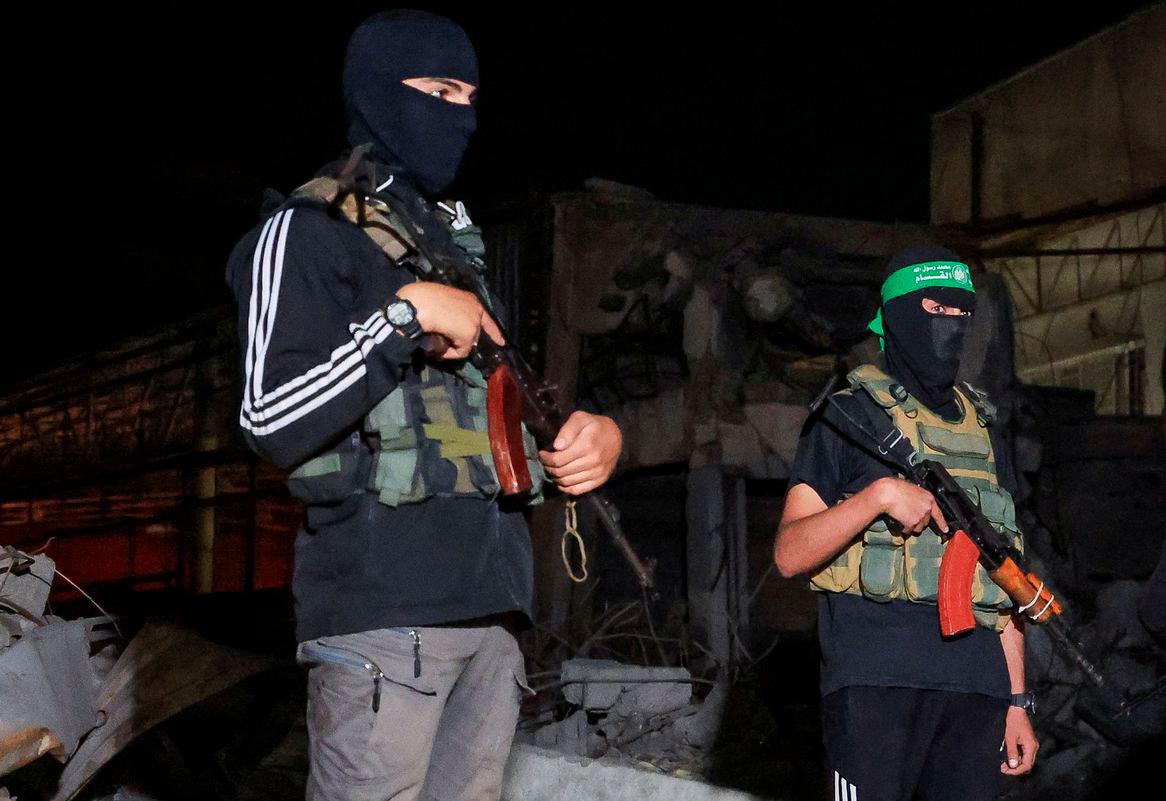 Hamas militants stand guard as Red Cross vehicles (not pictured) transport the bodies of hostages who were held in Gaza since the deadly October 7, 2023, attack, after they were handed over by Hamas militants as part of a ceasefire and a hostage-prisoner swap deal between Hamas and Israel, in Gaza City, October 15, 2025. - REUTERSPIX