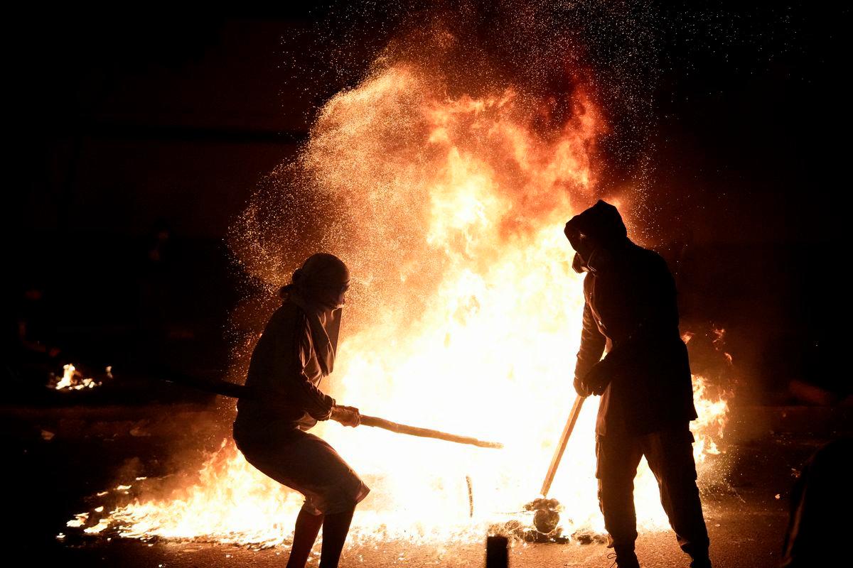 Demonstrators stand next to fire burning during a protest against rising crime, economic insecurity, and corruption, a day after President Jose Jeri presented his cabinet, in Lima, Peru, October 15, 2025. - REUTERSPIX