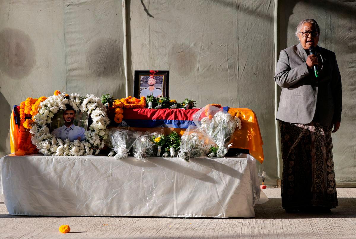 Nepal’s interim Prime Minister Sushila Karki delivers a eulogy as she stands next to the coffin of deceased hostage Bipin Josh. REUTERS/Navesh Chitrakar