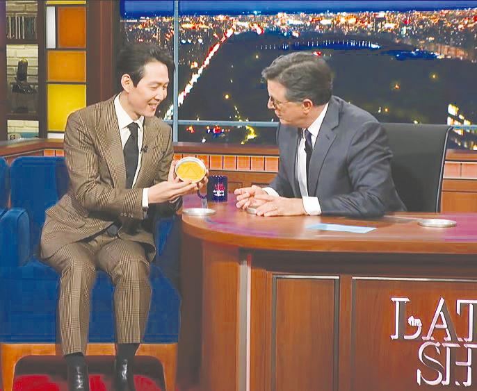 Lee showing Colbert how to play the Dalgona game. – The Late Show with Stephen Colbert