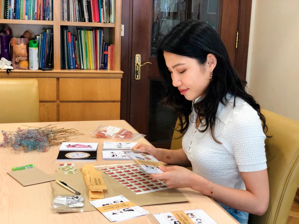 Choy creating her postcards. – COURTESY OF CHOY YUIN QUAN