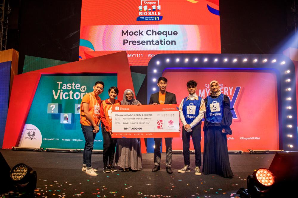 Shopee Malaysia marketing lead Lok Weng Lum (wearing jacket) presents a mock cheque for RM11,000 to Makna general manager Farahida Mohd Farid to launch the #ShopeeMakna 11.11 Charity Challenge. – ZULKIFLI ERSAL/THESUN