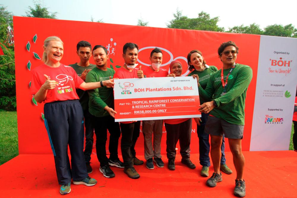 Proceeds from the 90th Birthday Fun Run is channeled to TRCRC, with Boh’s Caroline Russell (far left) handing over a mock cheque to TRCRC’s Dr Dzaeman Dzulkifli (far right). – BOH
