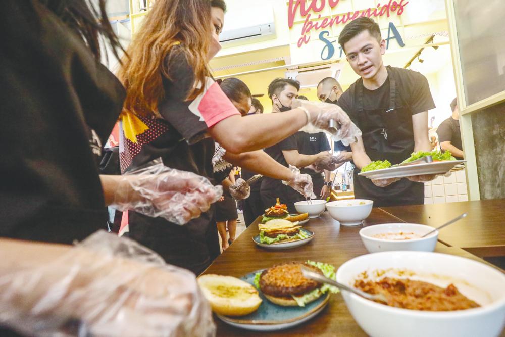 $!Members of the media got a chance to stack up the burger with step by step guidance from the chefs.