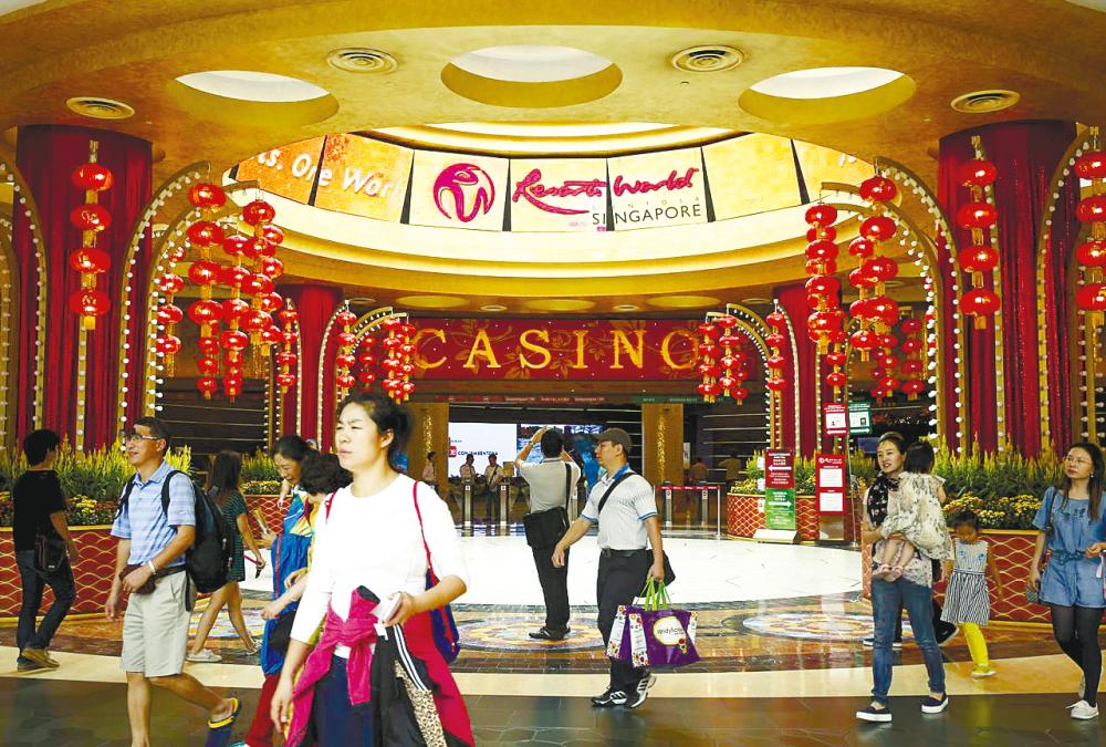 Visitors pass the Genting Singapore casino at Resorts World Sentosa in Singapore. – REUTERSPIX