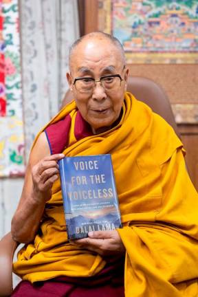 The Dalai Lama poses with his new book “Voice for the Voiceless” in this photograph posted on his X account on January 24, 2025 in India. REUTERSpix