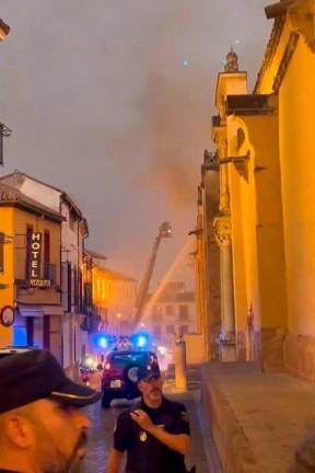 An image taken from a UGC video on August 8, 2025, shows Spanish police securing the area after a fire broke out in the historic mosque-turned-cathedral in the southern Spanish city of Cordoba firefighters said, with videos online showing flames and smoke coming from inside the major tourist attraction. AFP PHOTO /Victor Pulido Garcia / X