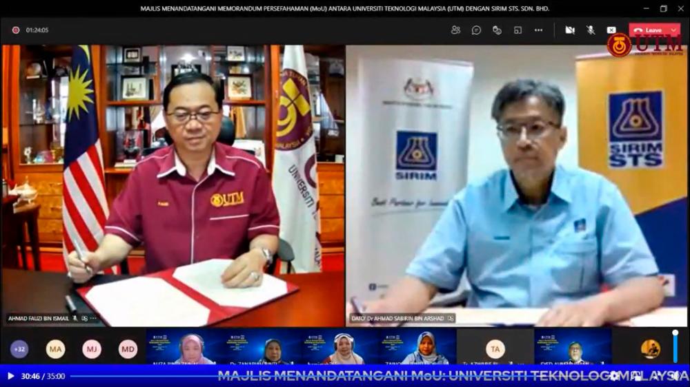 Ahmad Fauzi (left) and Ahmad Sabirin signing the MoU