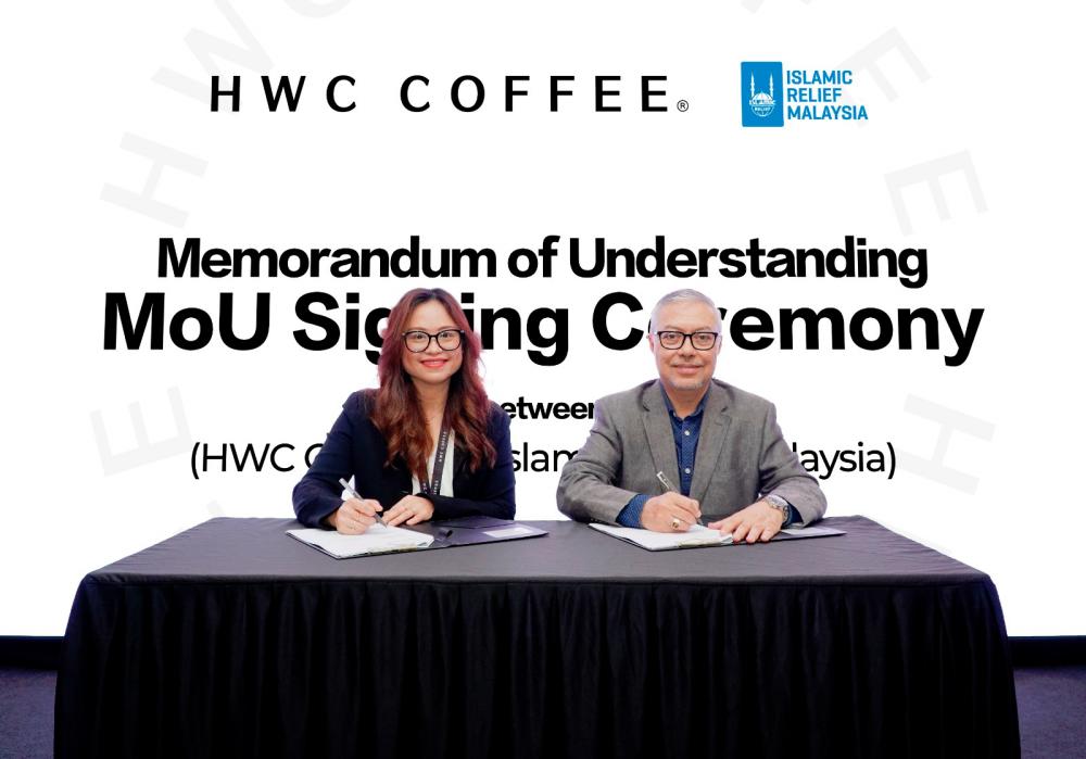 $!HWC Coffee Malaysia CEO Zenda Ng (at left) and Islamic Relief Malaysia board of trustees chairman Datuk Seri Syed Saleh Syed Abdul Rahman signing the MoU at the HWC Coffee outlet in Cyberjaya.