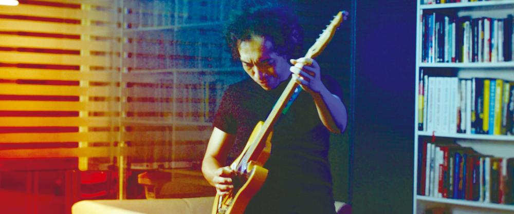 Azmyl playing the electric guitar in the Penghasut Blues music video.