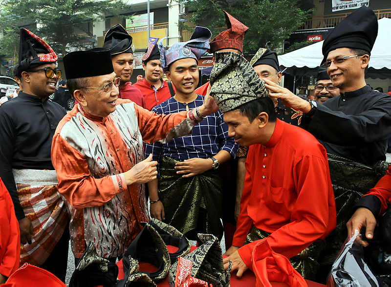 Negri Sembilan Parti Pribumi Bersatu Malaysia (Bersatu) chief Tan Sri Dr Rais Yatim fits a tanjak on Rembau Bersatu Chief Mohd Syazwan Shamsulbahar (2nd R), on Sept 16, 2019. — Bernama