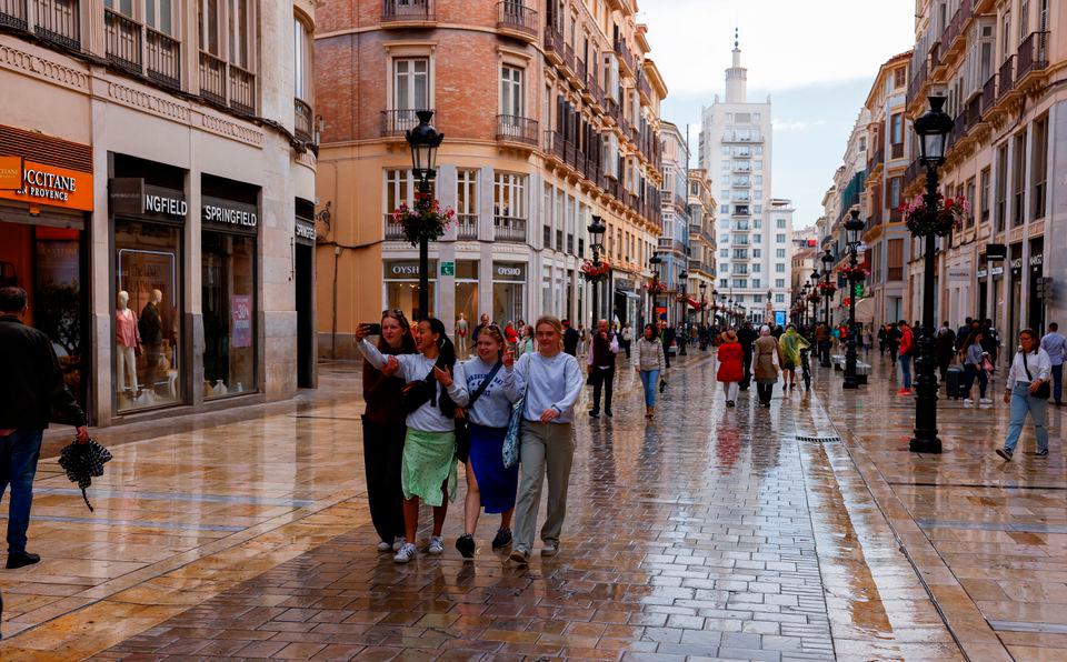 Tourists walk along a shopping street in central Malaga, Spain, April 28, 2022. REUTERSPIX