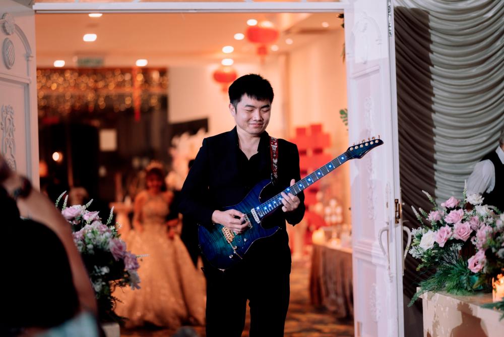 Eugene clearly enjoys performing at weddings, which can be seen in his smile.