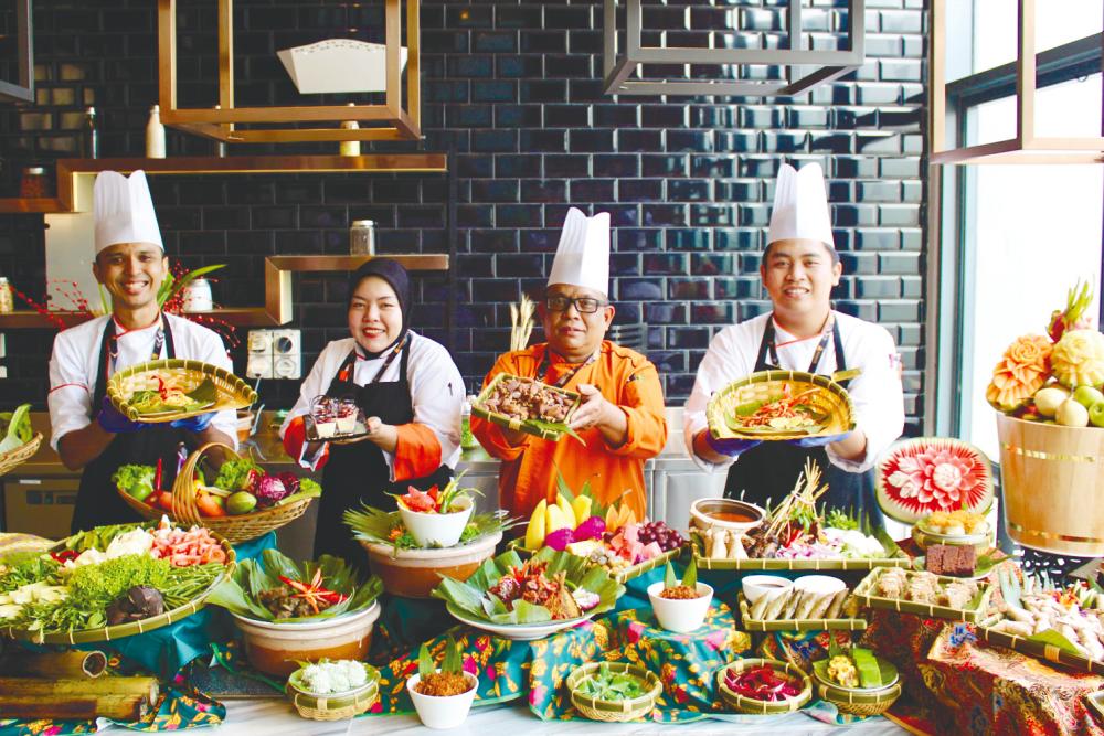 Chef Arih Ahmad (in orange) with his sous chefs. – AVANTE HOTEL