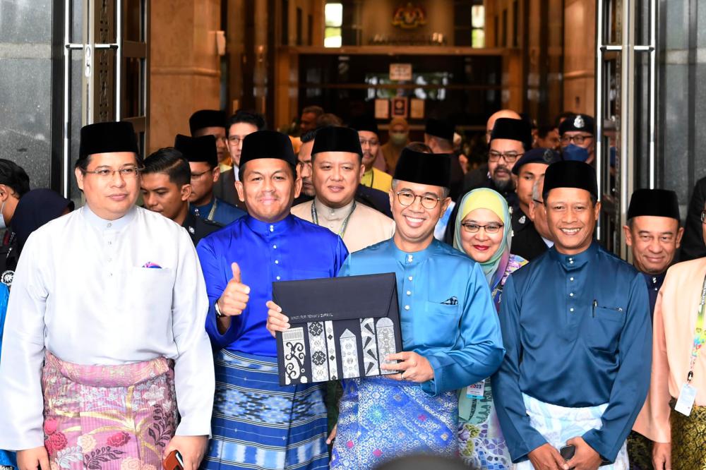 Clad in turquoise Baju Melayu, he was holding a black envelope containing the Budget 2023 speech text. Pix credit: Facebook/Tengku Zafrul