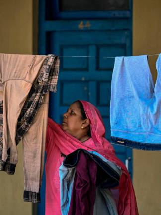 A displaced woman hangs clothes to dry at a Sikh temple in Jammu, a key city in Indian-administered Kashmir. - AFP