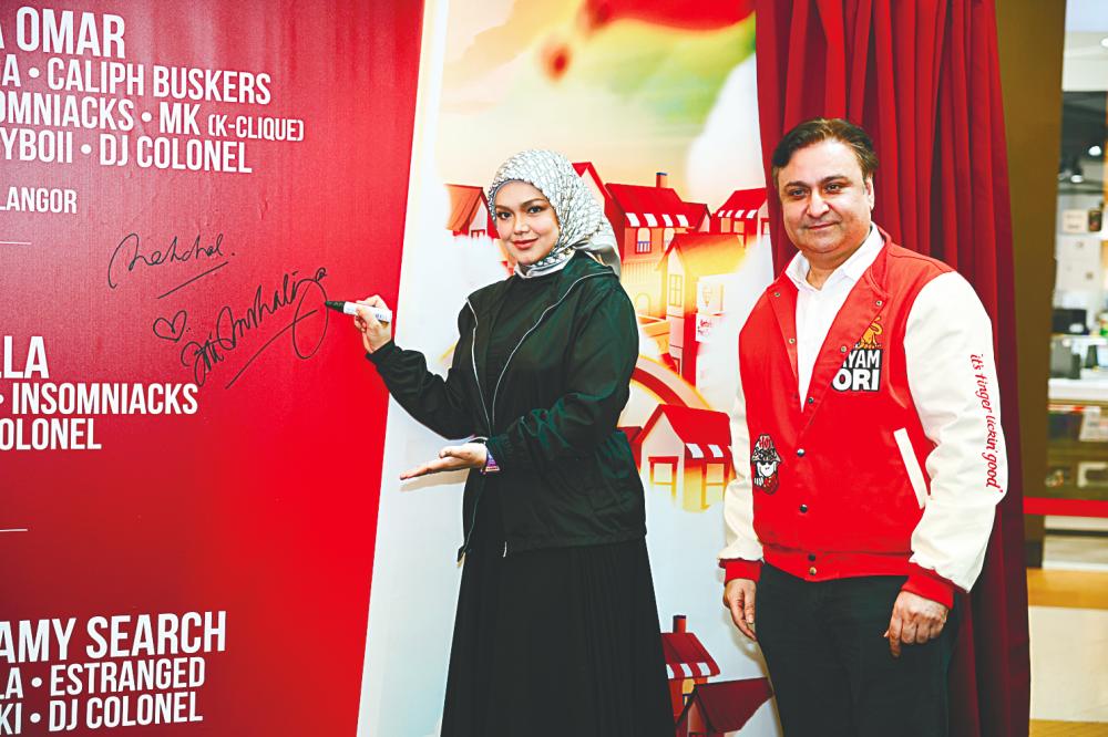 Siti signing her name. – KFC $!Siti signing her name. – KFC