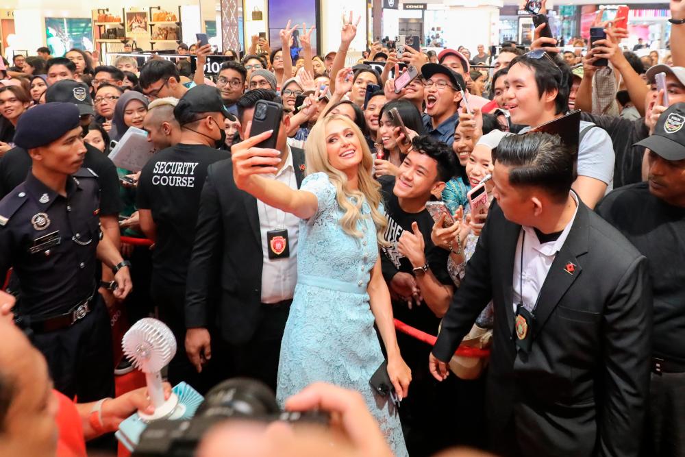 $!Above: Surrounded by security and the funny part was a woman was holding a fan for her. Perhaps, the climate was ‘too hot’ for the hot star.