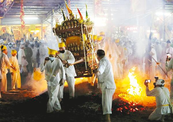 A group carrying the emperor’s sedan chair and walking on burning charcoal at the temple//Reuterspix