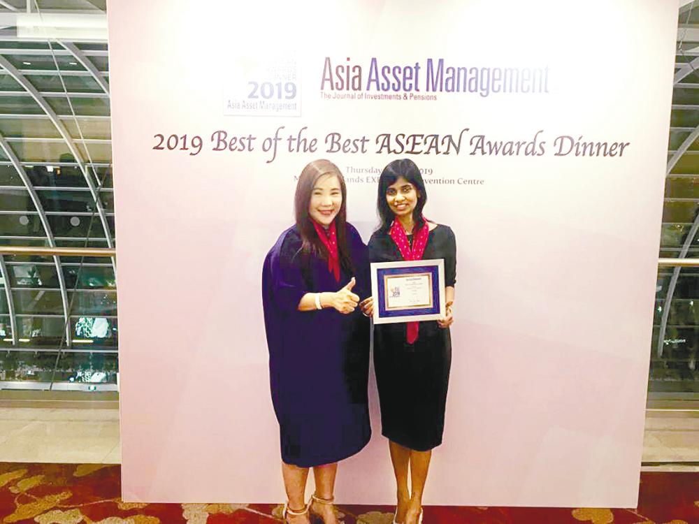 Goh (left) and AmInvest vice-president (institutional sales) Yasotha Kandasamy with AmInvest’s award as Best Pension Fund Manager, Malaysia, at the Asia Asset Management 2019 Best of the Best Awards held in Singapore on May 9.