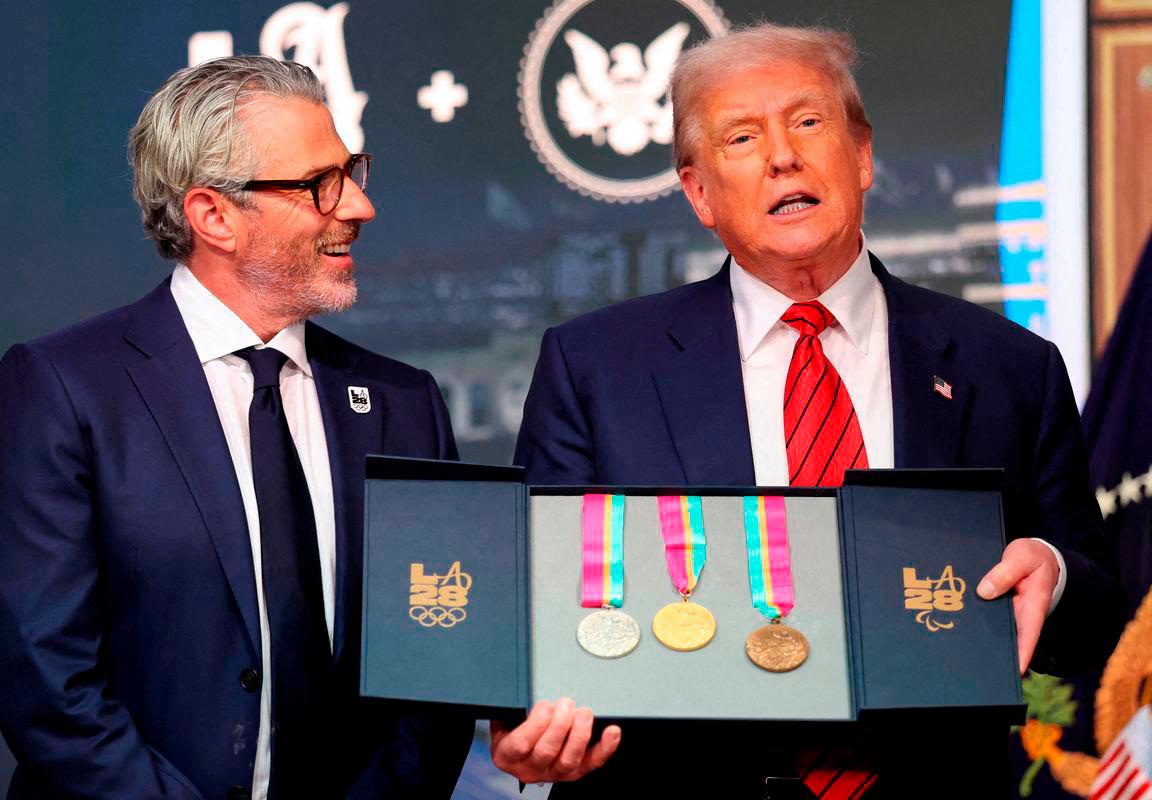 U.S. President Donald Trump, accompanied by LA28 Chairman Casey Wasserman, holds 1984 Los Angeles Olympics medals as he delivers remarks before signing an executive order to create a White House Olympics task force to handle security and other issues related to the LA 2028 Summer Olympics, in the South Court Auditorium on the White House campus in Washington. Reuterspix