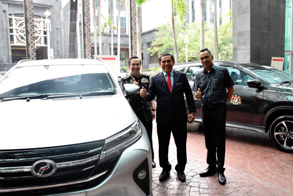 $!Perodua Sales Sdn Bhd managing director Datuk Zahari Husin (far right) with Muez (middle) Iskandar during the delivery of the 55 Aruz at KPDNHEP earlier today.