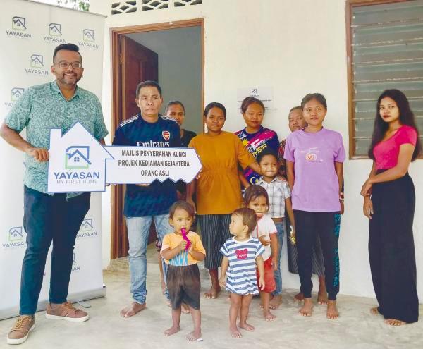 Nambee (left) with Chaman and his family during the handover of the house in Kampung Inoi, Pahang. – Pix courtesy of Yayasan My First Home