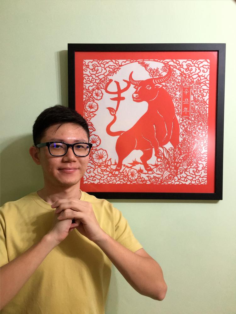 $!Chong with an artwork depicting the ‘Year of the Ox’. – COURTESY OF CHONG KAI ZEN