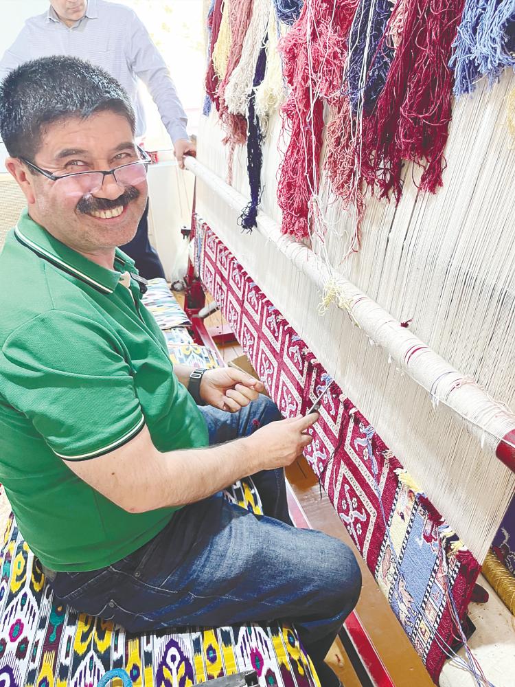 $!A carpet weaver demonstrating his techniques.