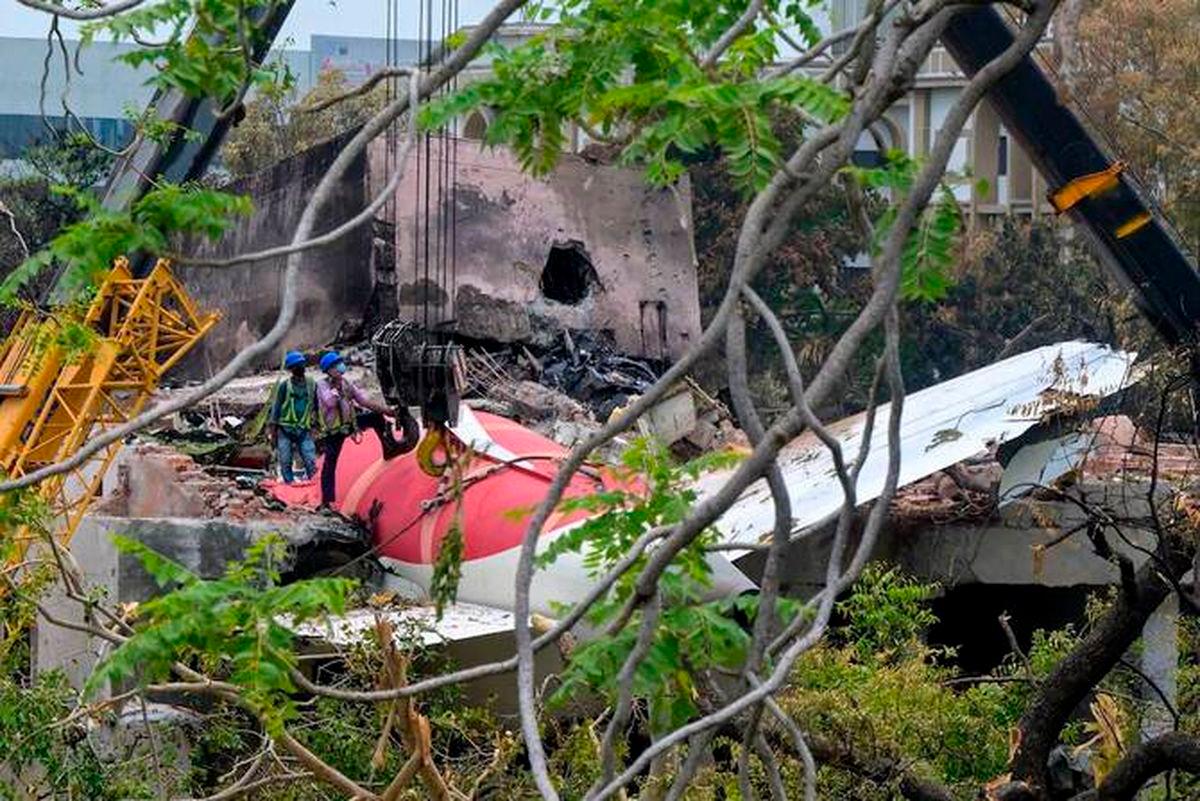 Cranes removing the tail from the wreckage after the Air India Flight 171 crash on June 14, 2025. (AFP)