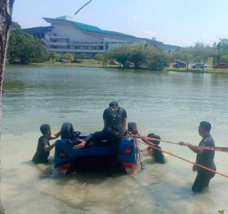 The vehicle by towed out of the lake. - Pics by Sarawak Fire and Rescue Department