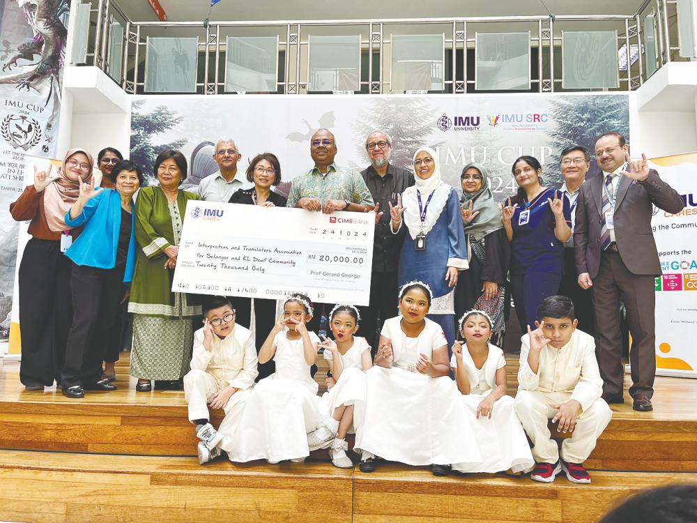 From left: Adibah Hakimi, author of book, Dr Dorothy D’Anne, advocate for the deaf community, Lim, Zubaidah, Suneet, Prof Khoo, Prof George and staff of IMU who supported the book project. Front row: deaf students from SK Pendidikan Khas, Jalan Peel, KL