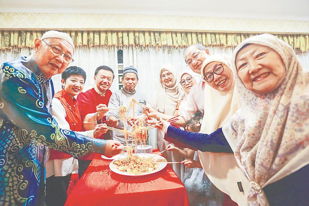 Macma members tossing a serving of ‘Yee Sang’ during the event on Sunday. – ADAM AMIR HAMZAH/THESUN