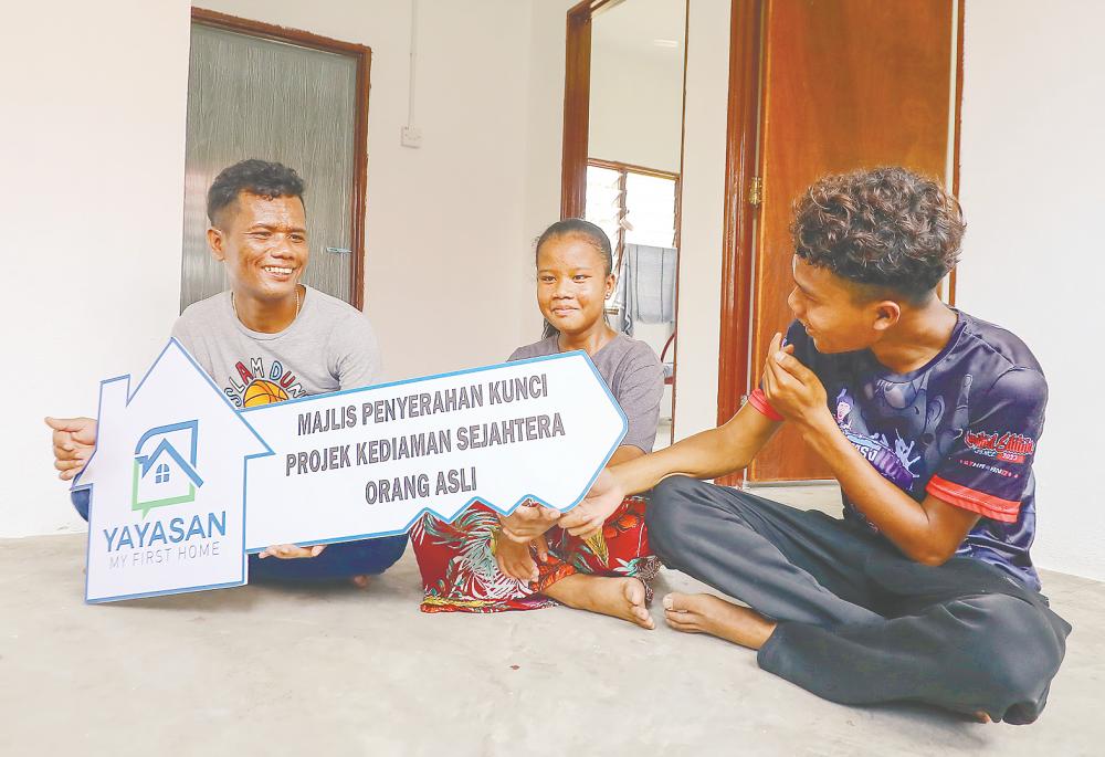 From left: YMFH beneficiary Bahchem, his daughter Alyka Harnata and son Hezkeneas posing for a photo in their new home at Kampung Sungai Bindu, Chenderiang in Tapah, Perak. – AMIRUL SYAFIQ/THESUN