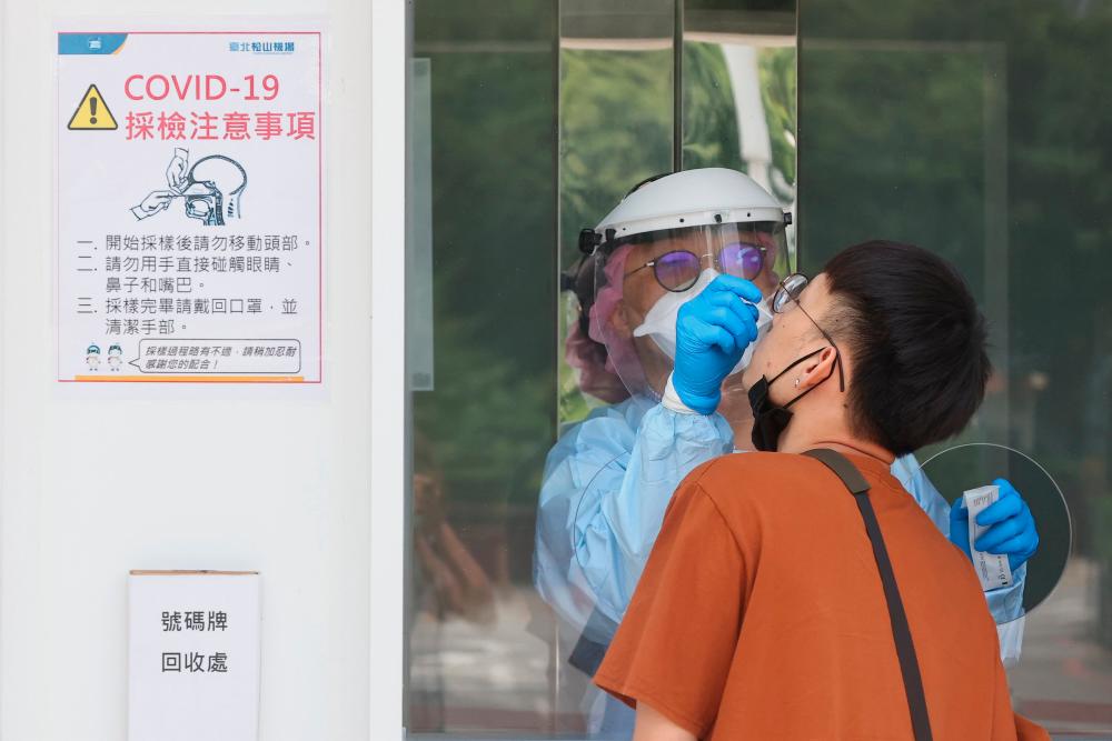 A medical worker conducts a rapid test for coronavirus disease (Covid-19) on a Taiwanese resident following an increasing number of locally transmitted cases at Songshan Airport in Taipei, Taiwan, June 2, 2021. -REUTERSPix