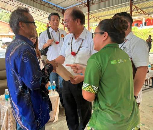 Native protestors speaking to Mulu assemblyman Datuk Gerawat Gala (white uniform in centre) and Telang Usan assemblyman Datuk Dennis Ngau (tall man in white uniform) against new dam projects in Baram. - Pic courtesy of Willie Kajan