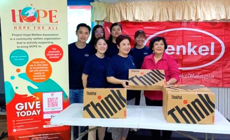 Teoh Tsu-Shien, President of Henkel Malaysia (front center), presents refurbished laptops to Lai Leen, Chairperson of Project Hope Welfare Association (front right).