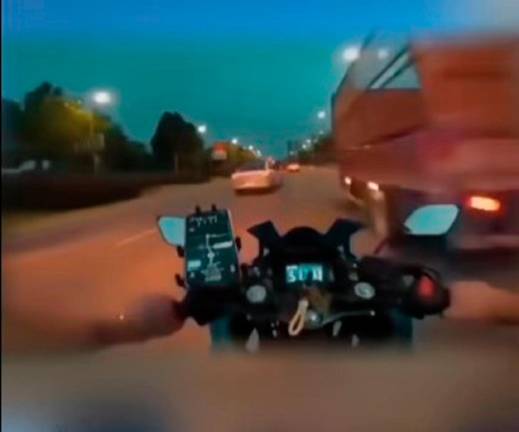 The motorcyclists as he is about to hit the metal rod protruding from the lorry. - Screenshot Virals NOW TV Facebook page