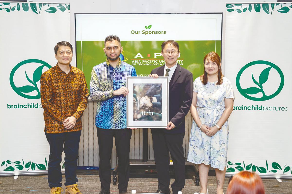 Deputy Minister Khairul, (second from left) hands over framed commemorative poster of Itam, to Dr Ho. Also present, filmmaker and director Tan, (first left) and Head of SoMAD, Debbie Liew.