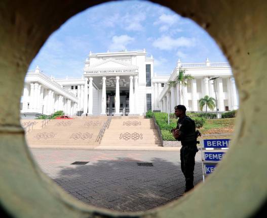 Police officers stand guard outside the Kota Kinabalu Court Complex for the inquest proceedings into the death of Zara Qairina Mahathir today. - Bernama pic