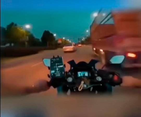 The motorcyclists as he is about to hit the metal rod protruding from the lorry. - Screenshot Virals NOW TV Facebook page