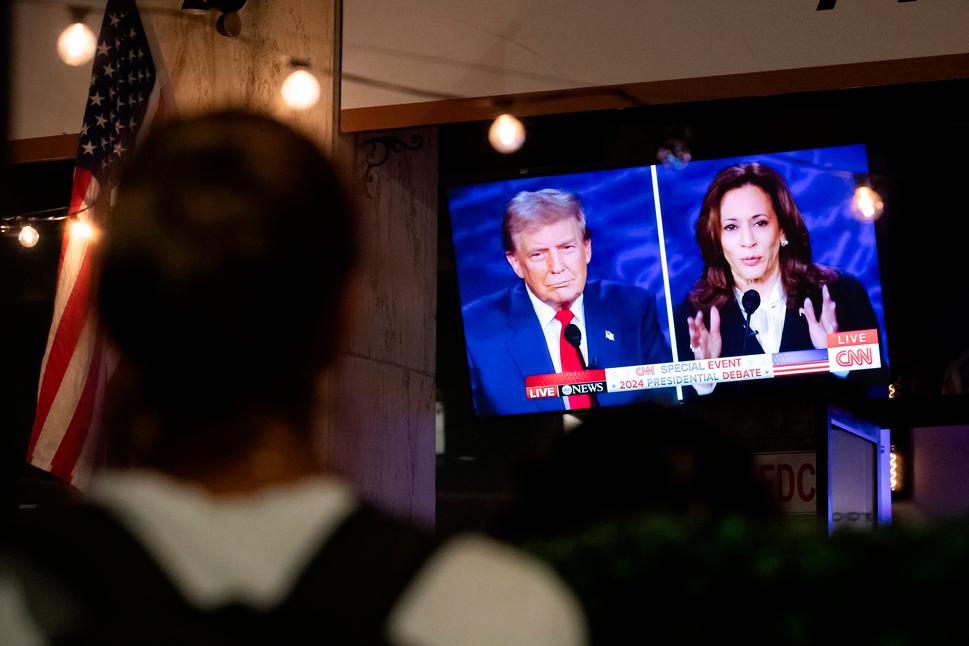 Two candidates for the US presidency. A person stops to watch a screen displaying the US Presidential debate between Vice President and Democratic presidential candidate Kamala Harris and former US president and Republican presidential candidate Donald Trump in Washington, DC, on September 10, 2024. (Photo by Allison Bailey / AFP)