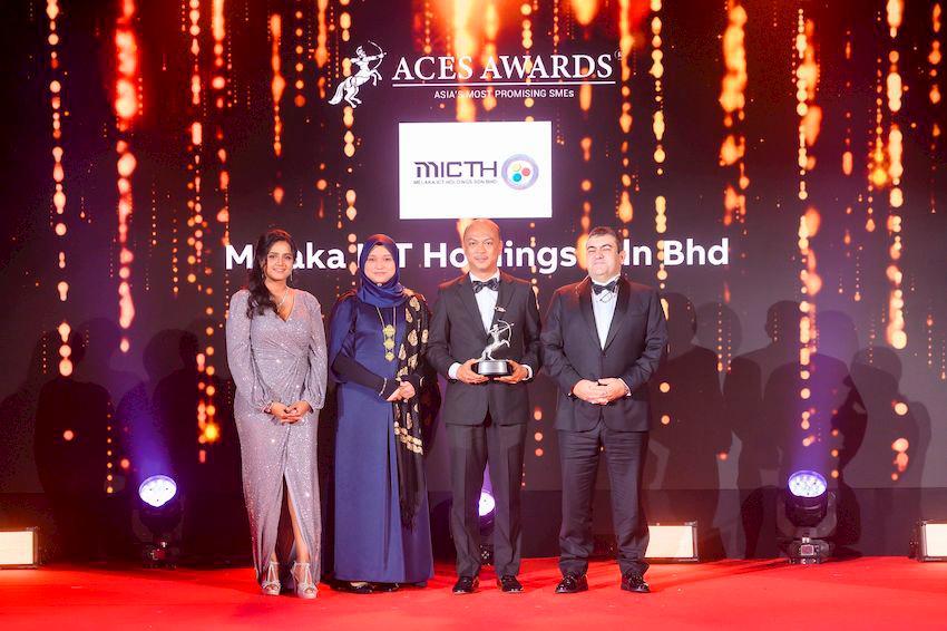 Dr. Nazdiana Ab Wahab, Chief Executive Officer of Melaka ICT Holdings Sdn Bhd (left center), and YB Datuk Fairul Nizam bin Roslan, Deputy Chairman of the Board of Directors (right center), proudly receive the Asia’s Most Promising SMEs award on stage at the ACES Awards 2024. The award is presented by Dr. Shanggari Balakrishnan, President of the ACES Awards (far left), and Mr. Luis Bueno Nieto, Advisor to the ACES Council (far right), in recognition of the Melaka ICT Holdings Sdn Bhd’s exceptional growth and promising future in the industry.