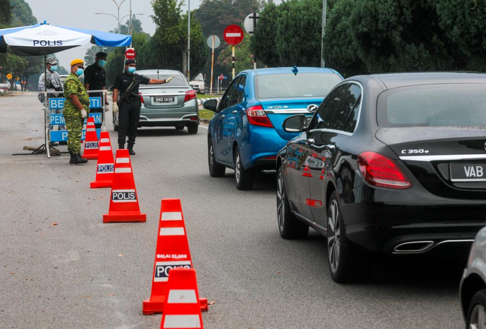 $!STRICT CHECKS ... Personnel from the police, army and People’s Volunteer Corps (Rela) man a roadblock set up as part of the conditional movement control order (CMCO) in Taman Seri Andalas in the Klang district, Selangor, yesterday. - ASYRAF RASID/THESUN