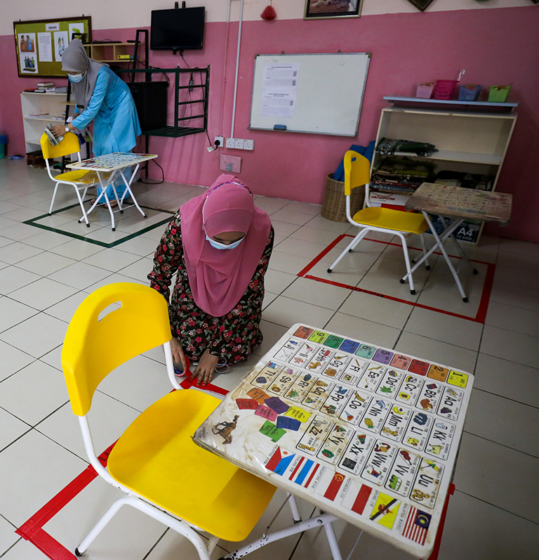 $!Teachers at Montessori Kindergarten in Shah Alam disinfecting tables and chairs and marking social distance with tapes in preparation to open classes tomorrow. – ASYRAF RASID/THESUN