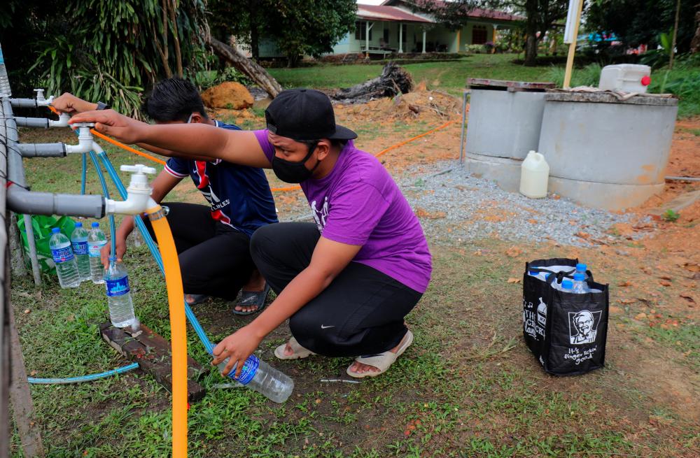 $!BOTTLE BRIGADE ... Residents collecting water from a relief tank in Shah Alam yesterday after the area and several others in the Klang Valley were hit by an unscheduled supply disruption. – ASYRAF RASID/THESUN
