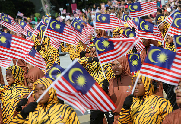 Performers wave flags during the 62th Merdeka Day celebrations in Putrajaya. — Sunpix by Asyraf Rasid