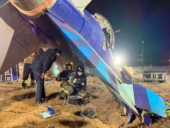 In this handout picture released by Kazakhstan's emergency situations ministry on December 26, 2024, emergency specialists work at the crash site of an Azerbaijan Airlines passenger jet near the western Kazakh city of Aktau. - AFP PHOTO / Kazakhstan's emergency situations ministry / handout